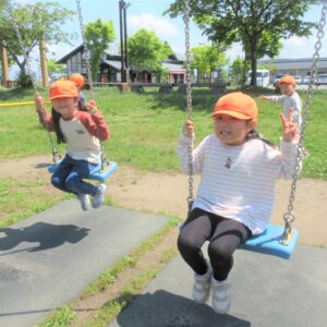 子どもたちが公園のブランコで遊んでいます