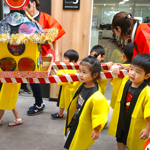 お祭りのような衣装を身につけた子供たちが、手作りの御輿を担いでいる