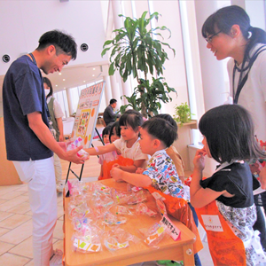 室内イベントで大人にプレゼントを渡す子供たち