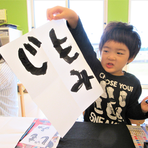 習字で書いた紙を掲げる男の子